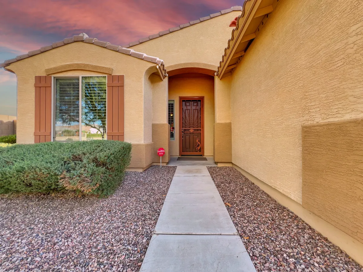 The home's front entrance with a welcoming door, neatly landscaped pathway, and well-maintained greenery. The scene suggests a safe and inviting neighborhood, hinting at walkability and the home's connection to its surroundings.