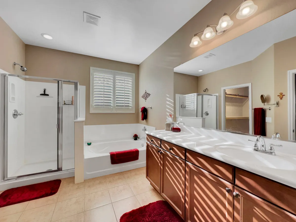 A serene bathroom featuring a bathtub, double vanity, and a separate shower stall. The space is designed for relaxation, with tranquil colors and thoughtful details to create a true spa experience.