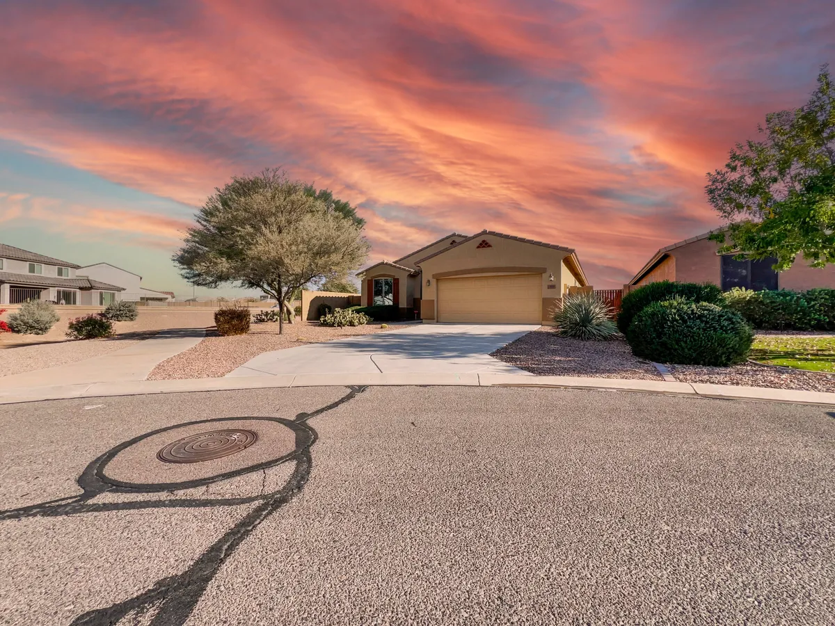 The home’s facade is showcased with tidy landscaping and a driveway, set against a beautiful sunset sky. The welcoming exterior hints at a peaceful, walkable neighborhood and the promise of comfortable living within.